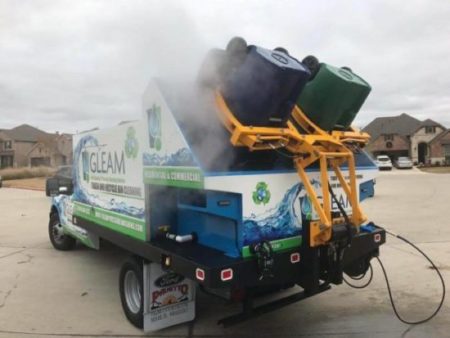 Un camion GLEAM pulisce un paio di bidoni della spazzatura